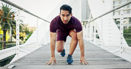 Portrait, start and man in city, runner and fitness with exercise, bridge and training. Asian person, outdoor and athlete with practice, hobby or cardio with workout and wellness in New Yorkの写真素材