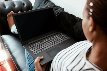 Woman, home and laptop screen on couch with blog post, remote work and freelance writing. Sofa, mockup space and female person on website as journalist for research, news and article publicationの写真素材