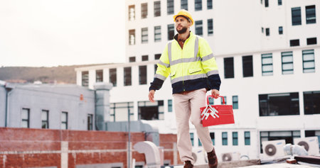 Handyman, outdoor or technician walking with toolbox on rooftop in city for ac machine repair labor. Maintenance, engineer or contractor on building fixing hcav for installation or safety inspectionの写真素材
