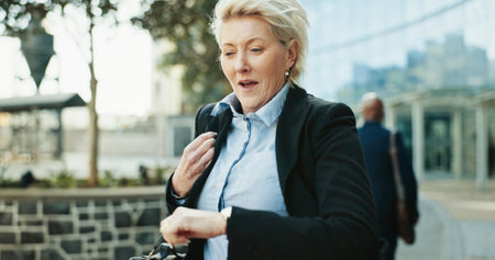 Running, business woman and check watch in city for urgent meeting, rushing to appointment and late. Mature professional, deadline and schedule mistake for morning commute and time management outdoorの写真素材