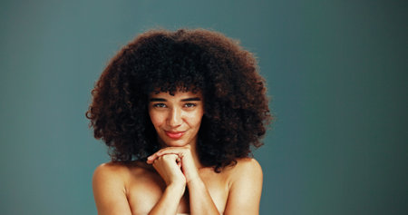 Portrait, proud and woman with afro hair care, studio and treatment for wellness and health. Face, growth or confident girl model with beauty, volume and natural texture on green background in Brazilの写真素材