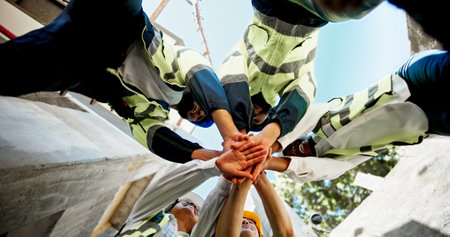 Construction, teamwork and hands together on site for support with building inspection and compliance success. Below, worker stack and people with celebration for project management and cooperationの写真素材