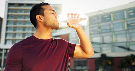 Man, drinking water and town athlete on break, liquid nutrition and sports drink for fitness. Male...