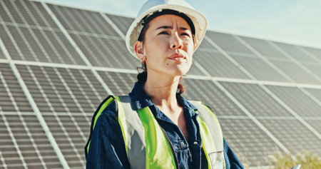 Solar panels, thinking and countryside with woman, sustainability and clean energy. Person, outdoor and employee with hard hat, eco friendly or professional with inspection, choice or quality controlの写真素材