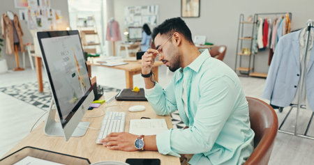Small business, man and stress on computer as fashion designer with clothes or logistics deadline....