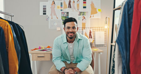 Clothes, creative and portrait of fashion designer man in textile workshop for production. Pictures, sketch and wall with happy style director at desk in office for clothing manufacturing processの写真素材