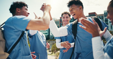 Medical success, students and happy with handshake outdoor for training program support or board exam results. Excited group, people and hand gesture for healthcare practice feedback and cheeringの写真素材