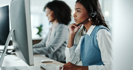 Call centre, serious and woman with headset, coworking and remote access of software and troubleshooting. Professional, IT and tech support with computer, advice and helpdesk for hardware issuesの写真素材