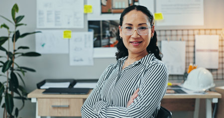 Portrait, woman or confident in office for architecture, career pride or opportunity for housing development. Engineer, glasses or arms crossed in firm for project management, creative or renovationの写真素材
