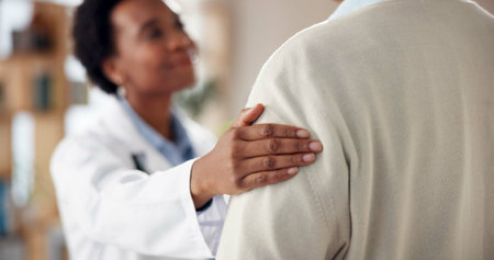 Care, woman and doctor with hand on shoulder for advice, kindness and service in clinic consultation. Support, comfort and medical professional with patient for empathy, help and hospital healthcareの写真素材