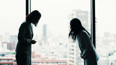 Japanese, business women and bow in office for respect, team or greeting as negotiation or meeting. Partnership, agreement and welcome with thank you, colleagues and collaboration in legal settlementの写真素材