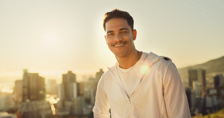 City, exercise and portrait of man runner outdoor for cardio or marathon training at sunrise. Fitness, smile and workout with happy athlete person in urban town for health, improvement or wellnessの写真素材