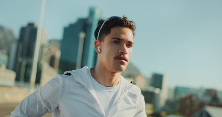 Man, runner and earphones for fitness in city with outdoor training, challenge and prepare for marathon. Person, athlete and listen to music, audio or streaming in street for exercise in Costa Ricaの写真素材