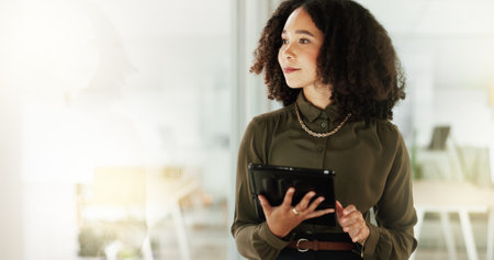 Woman, thinking and tablet at window for business, career opportunity and space in office. Female employee, technology and reflection at glass mockup for planning, mindset or bright future in companyの写真素材