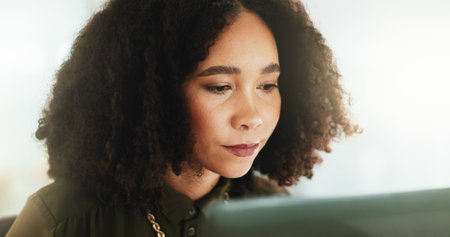 Concentration, face and laptop with business woman in office for administration or economic research. Afro, bookkeeping and computer with African accountant in workplace for financial managementの写真素材