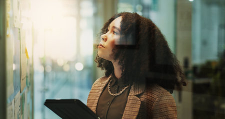 Thinking, tablet and business woman on whiteboard, planning project or research. Tech, idea and African worker with creative solution, insight or problem solving for social media campaign in startupの写真素材