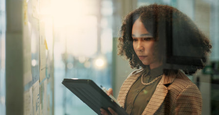 Research, tablet and business woman planning project, scroll or reading email on internet. Technology, app or creative African employee working on campaign or ads for social media platform in startupの写真素材