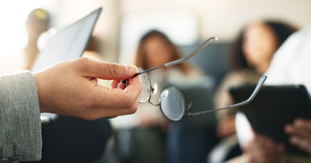 Glasses, hand and person with meeting in office for finance report at startup business. Discussion, speaker and closeup of financial executive with spectacles for presentation, event or seminar.の写真素材