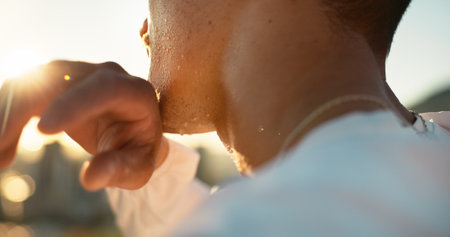 Chin, hand and sweating with sports person outdoor in nature closeup for exercise or fitness. Cardio, challenge and intense with athlete wiping perspiration from skin for marathon training or workoutの写真素材