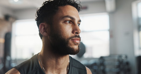 Man, sweating and thinking as tired in workout, intense exercise and wellness with fatigue. Male person, recovery and exhausted as athlete for health, challenge and training in fitness, sports or gymの写真素材