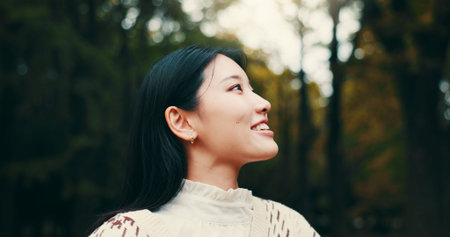 Japanese woman, thinking and outdoor with smile, confidence or pride in garden or park. Female person, happiness and biology student at university for relax, ideas or planning as gen z in countrysideの写真素材
