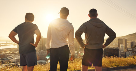 Back, city and fitness with runner men outdoor for break from exercise, sports or training routine. Cardio, sunrise and view with athlete people in urban together for marathon workout as teamの写真素材