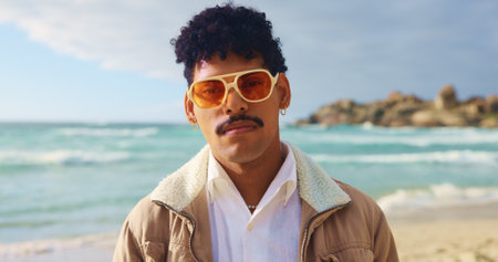 Portrait, man and sunglasses on beach outdoor for summer vacation, travel destination and nature tourism. Male person, fashion and streetwear for holiday break, tropical adventure and Florida getawayの写真素材