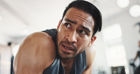 Gym, asian man and tired with breathing for workout, cardio training or exhausted for health fitness. Sweat, male person and bodybuilder with thinking for exercise session, wellness rest or challengeの写真素材