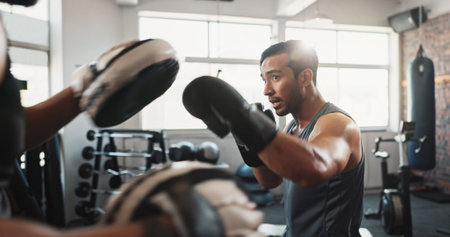 Boxing, man and personal trainer in fitness gym with workout, power and training for sport and strength in club. Coach, health and sweating athlete and boxer with exercise for fight and matchの写真素材