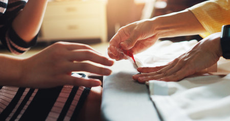 Fashion designer, tailor and hands of women in workshop for stitch, manufacturing or process. Teamwork, boutique business and people with material, fabric or textile for seamstress service in Japanの写真素材
