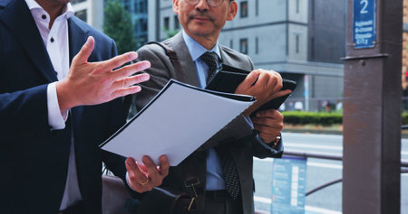 Documents, discussion and business men in city with finance report for stakeholder revenue. Meeting, paperwork and male financial advisors with profit, capital gain or investment agreement in Japan.の写真素材