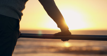 Hand, railing and reflection at beach, sunset and promenade in summer with blur, mindset and insight on vacation. Pier, person and inspiration by sea, ocean and outdoor by water at dusk in Costa Ricaの写真素材