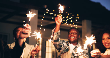 Outdoor, night and happy as friends with sparklers for new year and festive season celebration....