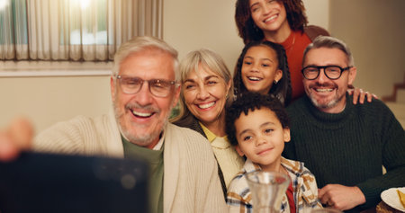 Grandparents, happy and selfie of family in home for lunch, supper and Christmas dinner together. Thanksgiving, picture and parents and children with memory for festive event, holiday or celebrationの写真素材