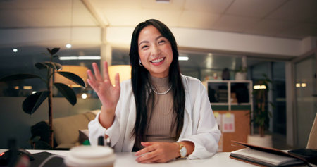 Asian woman, portrait and night with wave for video call, online conference or webinar at office...
