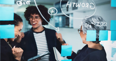 Happy, business people and night with tablet for winning, teamwork or celebration at office. Excited, group or employees working late with smile or technology for good news, offer or project successの写真素材