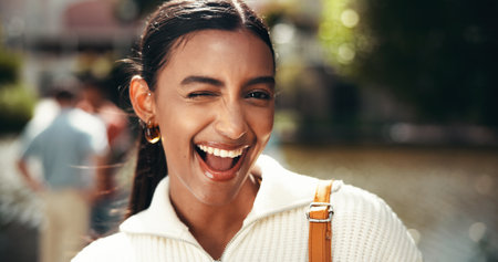 Excited, portrait and woman on vacation, wink and happy for international trip, outdoor and tourism. Travel, tourist and student on spring break, location and Indian person on holiday and Mumbaiの写真素材