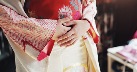 Hands, kimono and traditional with style for person with embroidery, history and design at store. Tailor, clothes and culture with material, silk and heritage with indigenous fashion at shop in Japanの写真素材