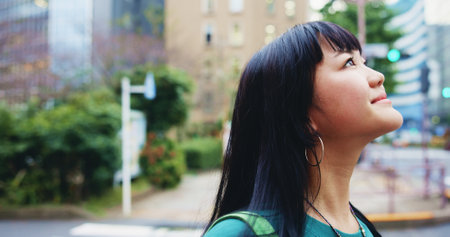 Thinking, travel and Japanese woman in city with adventure decision, choice or option outdoor. Happy, ideas and female person in town with memory, reflection or wonder on vacation, holiday or journeyの写真素材