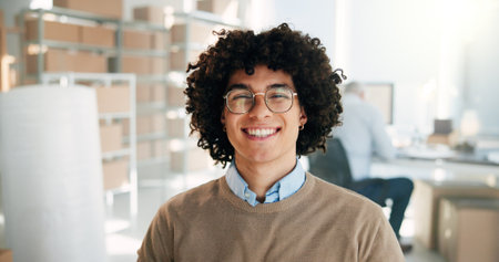 Portrait, distribution and happy man in small business for shipping, supply chain and service. Smile, face and professional entrepreneur at logistics warehouse for ecommerce and glasses at startupの写真素材