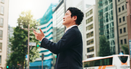 Outdoor, research and man with smartphone, thinking and real estate agent in city and comparing of prices. Morning, mobile and competition analysis for business, realtor or Japanese person in Japanの写真素材