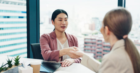 Japanese women, handshake and agreement for business deal, integration or investment merger. Team, smile and shaking hands for partnership opportunity, b2b contract and collaboration offer in officeの写真素材