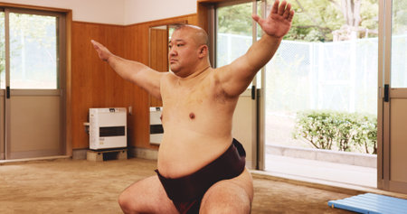 Athlete, training and exercise for sumo, wrestler and fitness with preparation, skill and technique in ring. Japanese man, fighter and sports in dohyo for culture, workout and wrestling with warm upの写真素材