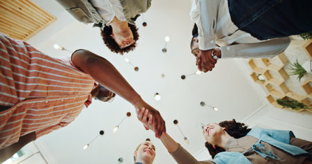 Handshake, low angle and teamwork with business people in office for contract negotiation, agreement and thank you. Partnership, congratulations and achievement with group of employees in startupの写真素材