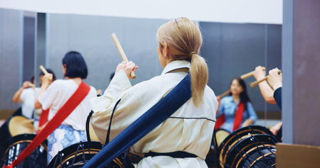 Japanese, back and people with drums for music on instrument for performance, practice and class. Taiko, women or female drummers learning in band to play in rehearsal for culture, rhythm or beatの写真素材