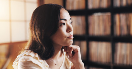 Thinking, serious and Asian woman in home, creative and writer with inspiration, ideas and remember. House, contemplating and planning for self publishing, entrepreneur or mindset for future in Japanの写真素材