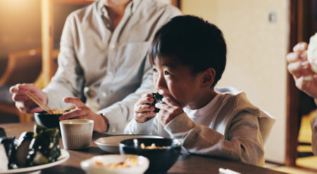 Japanese boy, family and eating in home with youth, lunch and dining room together with sushi. Food, hungry and dinner table with diet, kid and care with chopsticks and meal for health and nutritionの写真素材