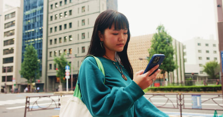 Japanese, woman and travel with phone in city for communication, social media and chat notification. Girl, commute and mobile for navigation app of location, reading blog and website texting in Japanの写真素材