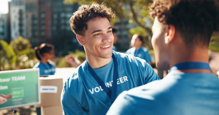 Teamwork, volunteer man and charity as friends for community service, project or nonprofit program. People, happiness and together as collaboration, outdoor and initiative for help, donations and NGOの写真素材