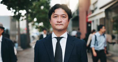 Japanese man, city street and portrait for pride as attorney in law firm, business or company. Male person, outdoor and confidence as legal professional with morning commute, career and serious faceの写真素材